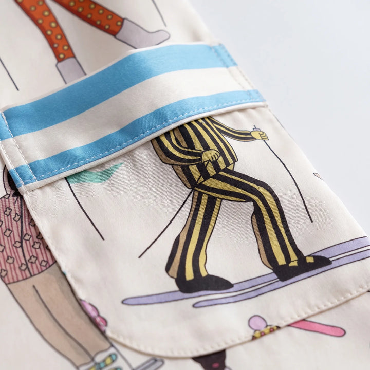 Close-up of the chest pocket with blue and cream striped flap, showing a skier in yellow striped pants and the stitching. 5