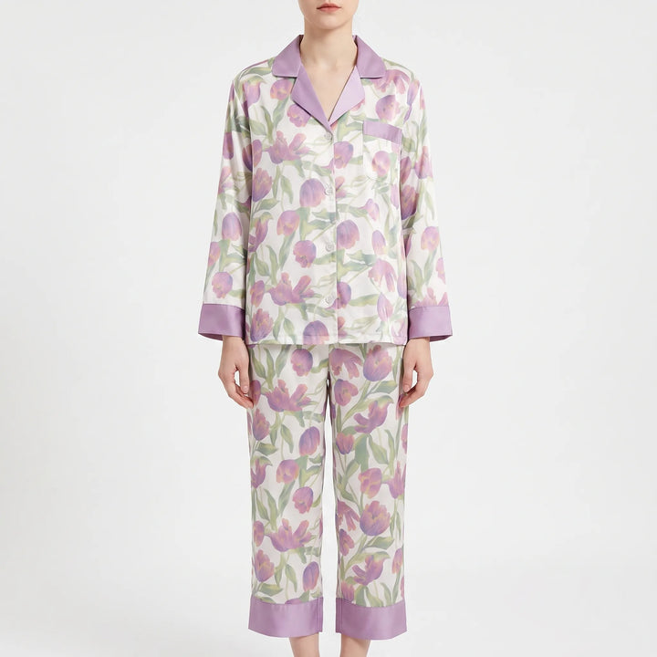 Model wearing a pajama set with purple tulips on white, lilac collar and cuffs, and cropped wide-leg pants. 7
