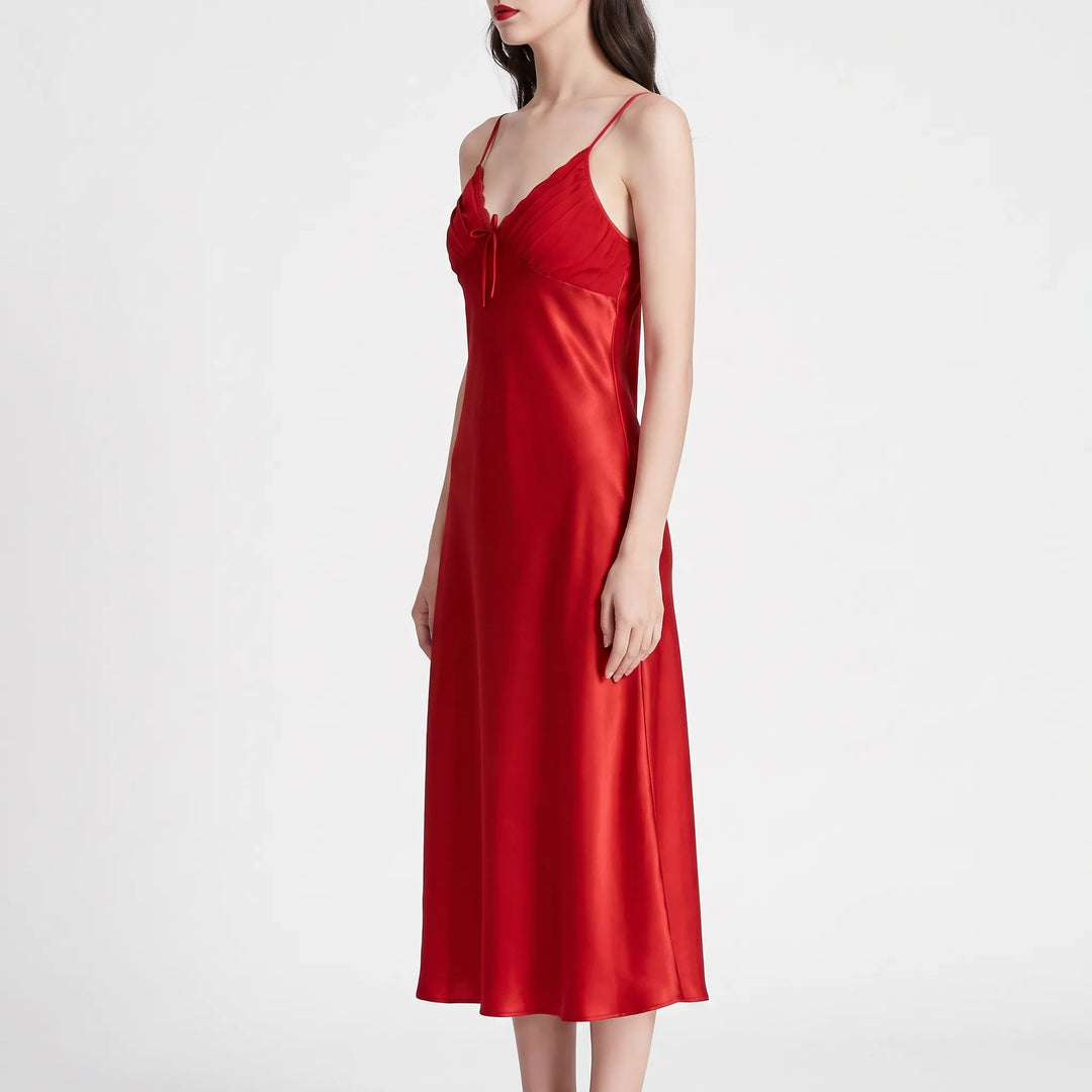 Side view of the red satin nightdress on a model against white, showing its long flowing line and fitted bodice. 4