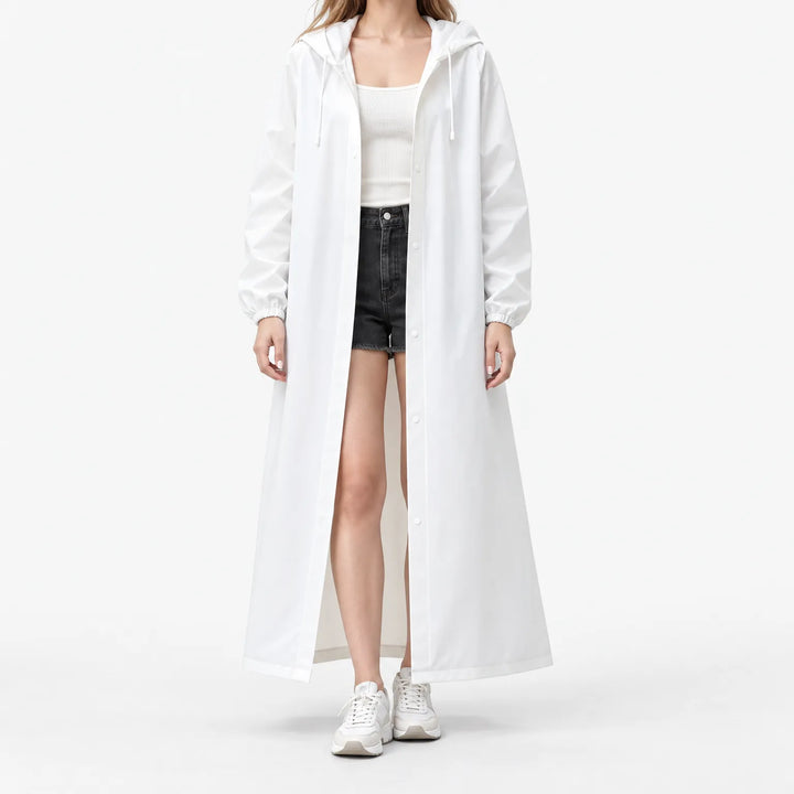 Studio front view of a model in the white hooded coat worn open over a ribbed tank and denim shorts. 2