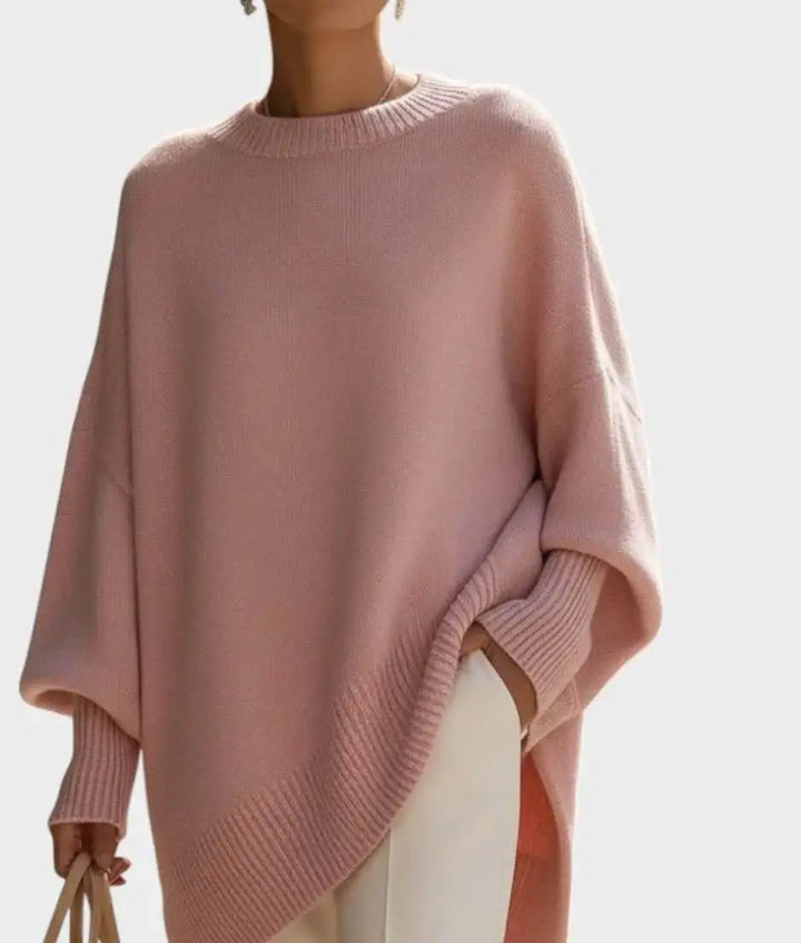 Pink oversized knit sweater with ribbed cuffs and hem on a light background, one hand holding a bag 10