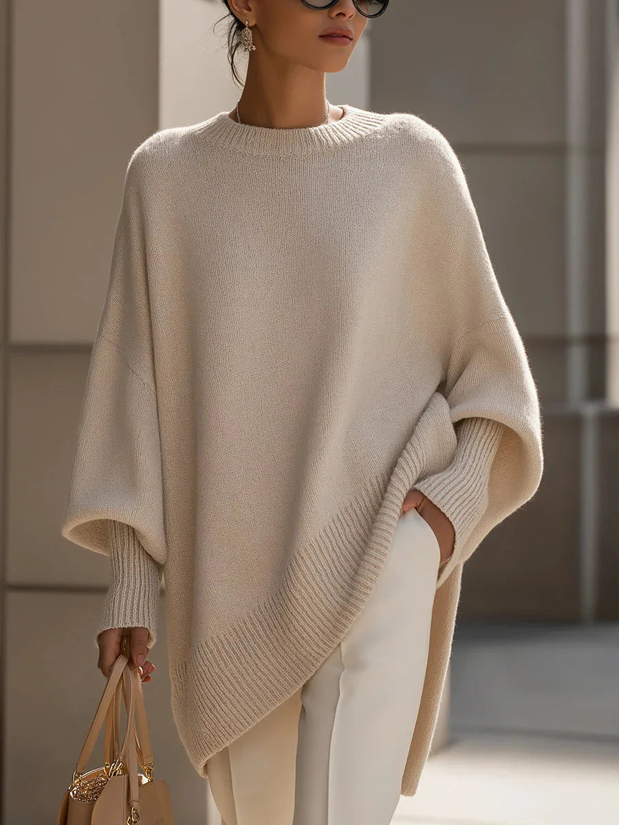 Cream knit sweater with ribbed hem, cuffs and neckline, worn by a model with glasses and white trousers 16