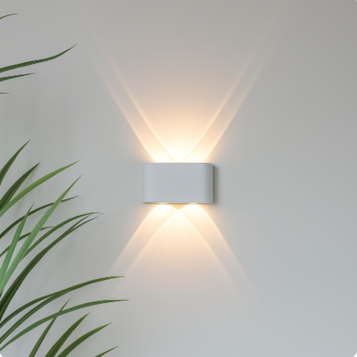 White rounded-rectangle wall light detail with two openings, projecting warm crossing beams up and down a light wall.
