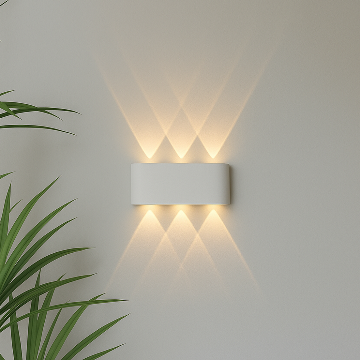 White wall light detail with three upward and three downward warm beams that overlap into triangle patterns on the wall.