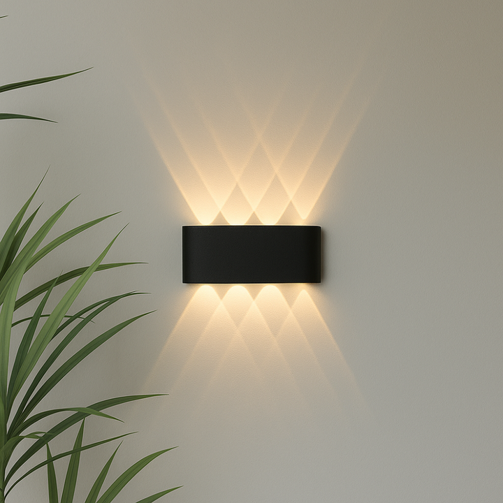 Wide black wall light detail with four beams pointing up and four down, forming a layered diamond pattern on the wall.