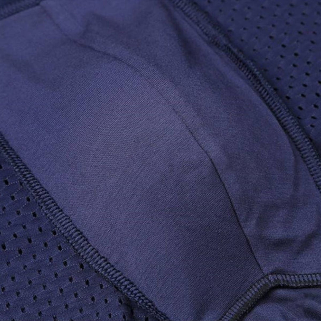 Close-up inside a navy boxer brief showing the smooth pouch lining, overlock stitching and perforated mesh side panels. 8