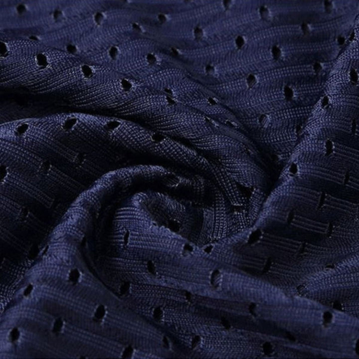 Close-up of crumpled navy perforated mesh fabric showing the textured weave and small ventilation holes. 9