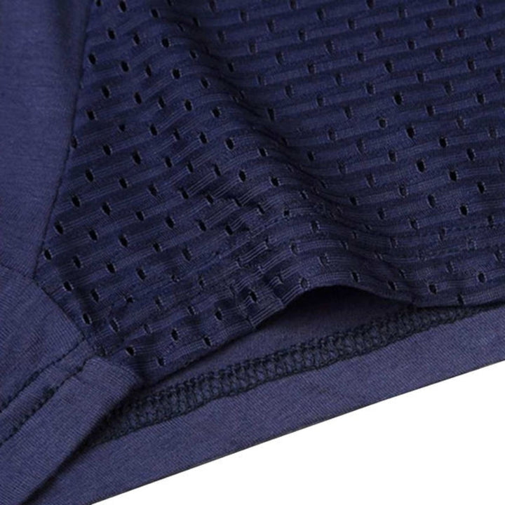 Close-up of a navy boxer brief leg opening showing the perforated mesh panel, smooth fabric and finished hem stitching. 11