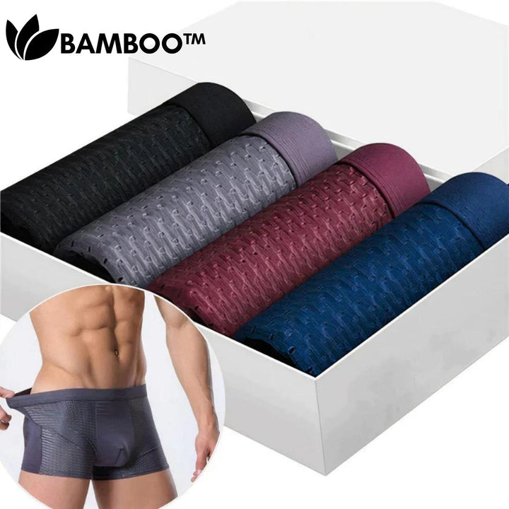 Four rolled boxer briefs in black, gray, burgundy and blue lined up in a white gift box, with a model inset. 2