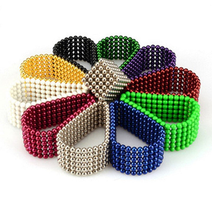 Flower-shaped arrangement of magnetic balls formed into looped bands in black, green, white, red and blue.