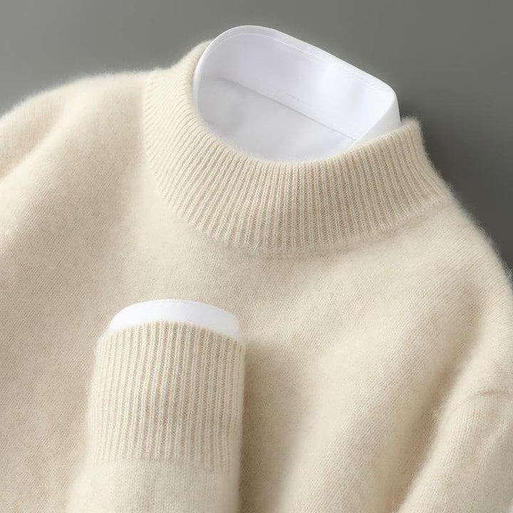 Cashmere sweater in cream with a ribbed mock neck and white shirt collar and cuff peeking out.