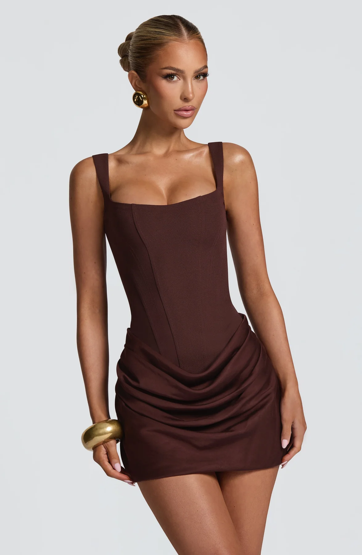 Brown mini dress with a structured bodice and draped skirt, detail.