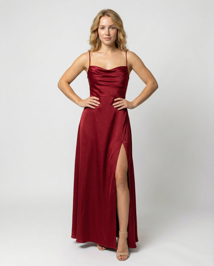Model in a red satin cowl-neck maxi dress with thin straps and a high leg slit, front view.