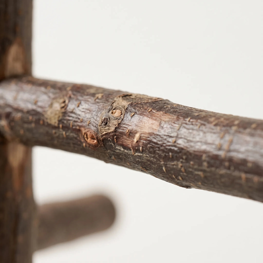 Close-up of a rough, knotted wooden rung showing the natural bark texture and small knots where it meets the main branch. 3