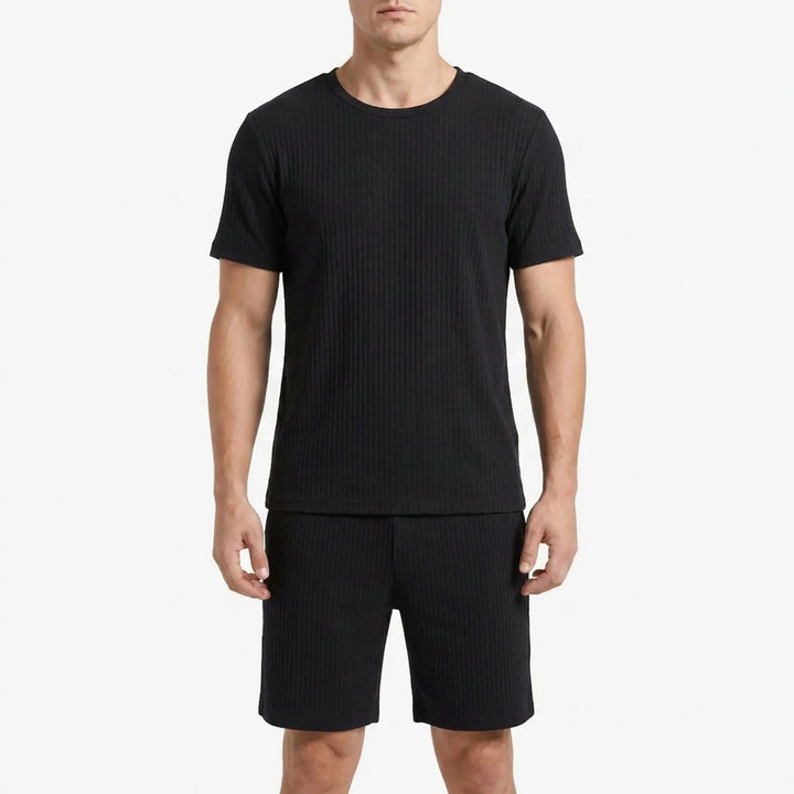 Man wearing the same ribbed short-sleeve pajama tee and shorts in black, shown from the front on a white background. 6
