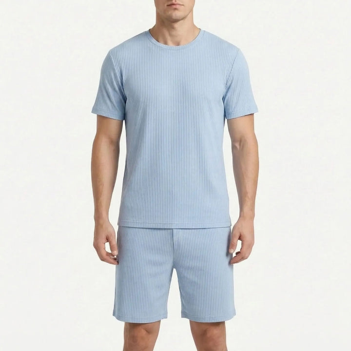 Front view of a model in the ribbed pajama tee and shorts in a muted powder blue shade on a white background. 8