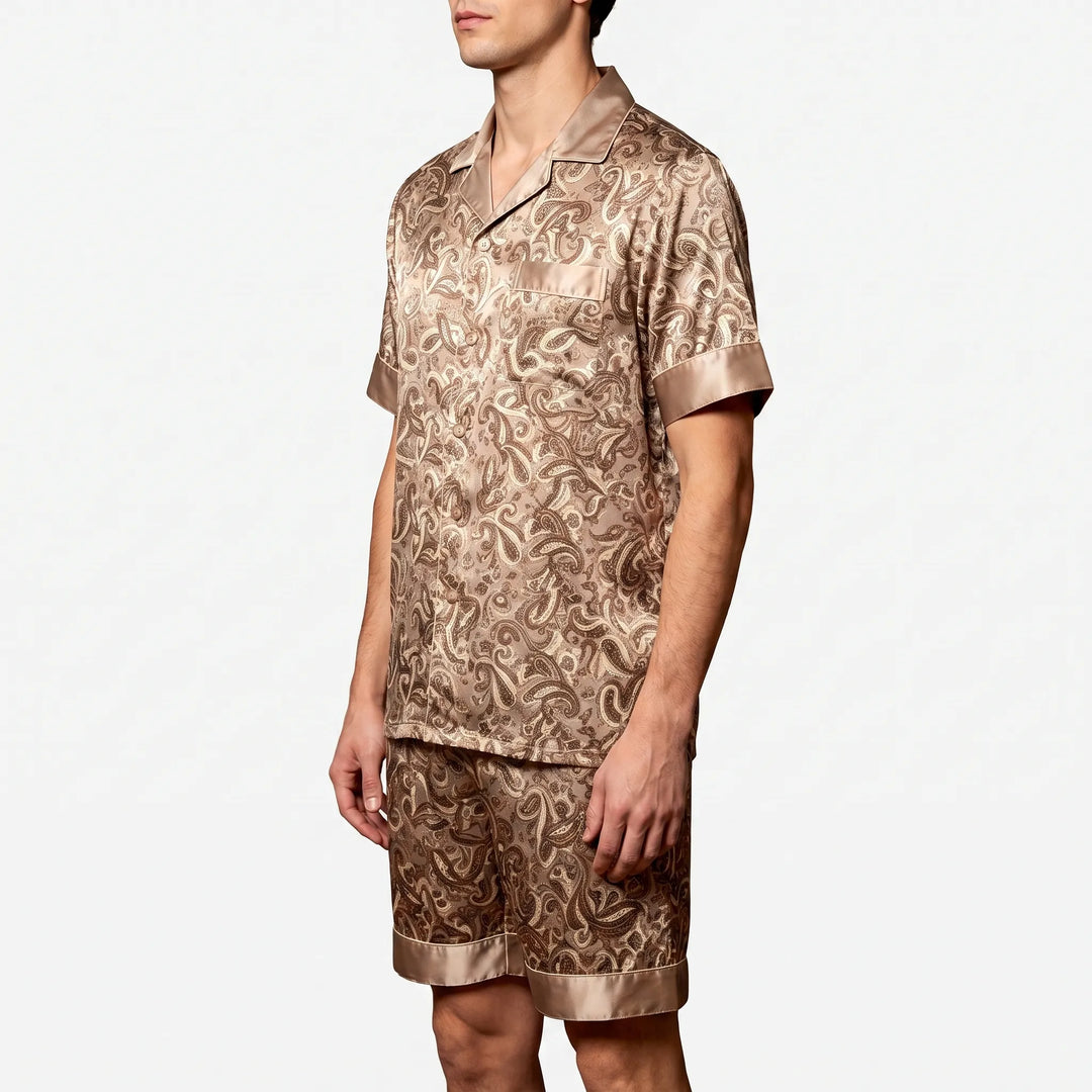Three-quarter side view of a model in the tan paisley satin set, showing the chest pocket and button front. 3