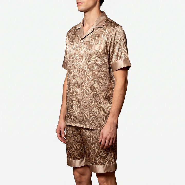 Three-quarter side view of a model in the tan paisley satin set, showing the chest pocket and button front. 3