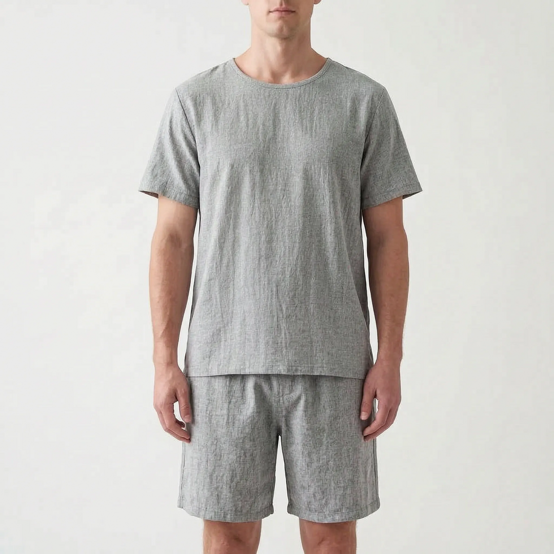 Front view of the same short sleeve tee and shorts set in a heathered gray, worn by a model. 7