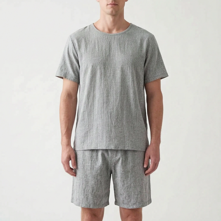 Front view of the same short sleeve tee and shorts set in a heathered gray, worn by a model. 7