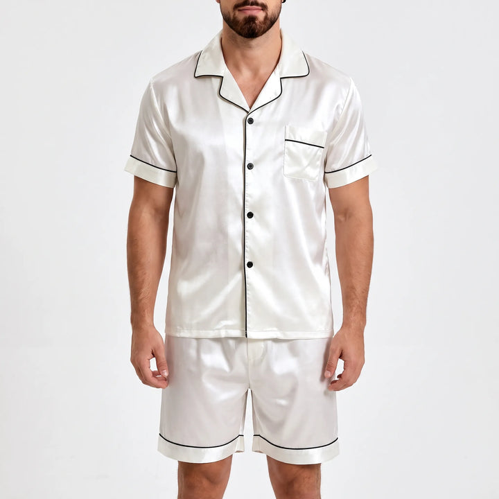 Front view on a plain background: white satin short sleeve shirt with black piping, chest pocket, black buttons, and matching shorts. 2