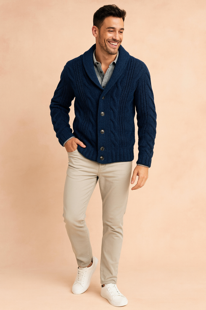 Full-length view of the navy cardigan worn with khakis and white sneakers against a peach backdrop 2