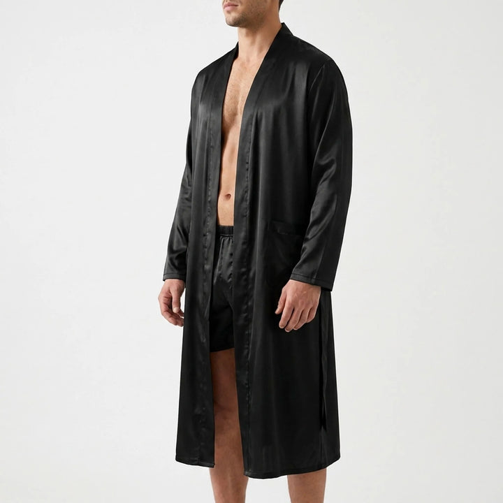 Three-quarter side view of a model in the open black satin robe and matching shorts, showing a patch pocket and long sleeve. 4