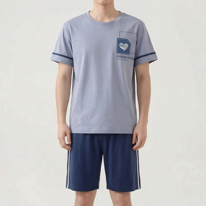 Model wearing a gray-blue tee with a small heart patch and navy sleeve bands, paired with navy shorts with white side stripes. 11