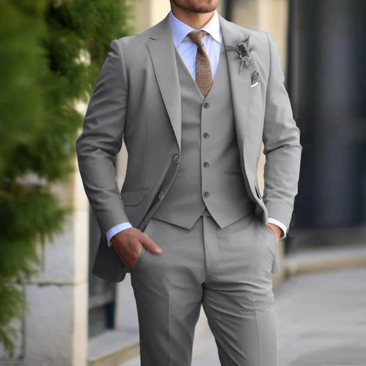 Same three-piece look in light gray, worn with a white shirt, brown tie and a small boutonniere 3