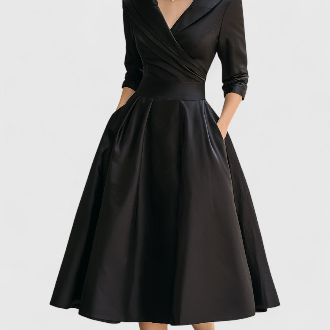 Black satin dress front view with a pleated wrap bodice, waistband and full flared skirt.