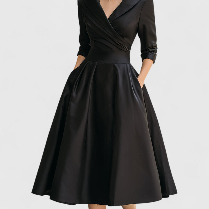 Black satin dress front view with a pleated wrap bodice, waistband and full flared skirt.
