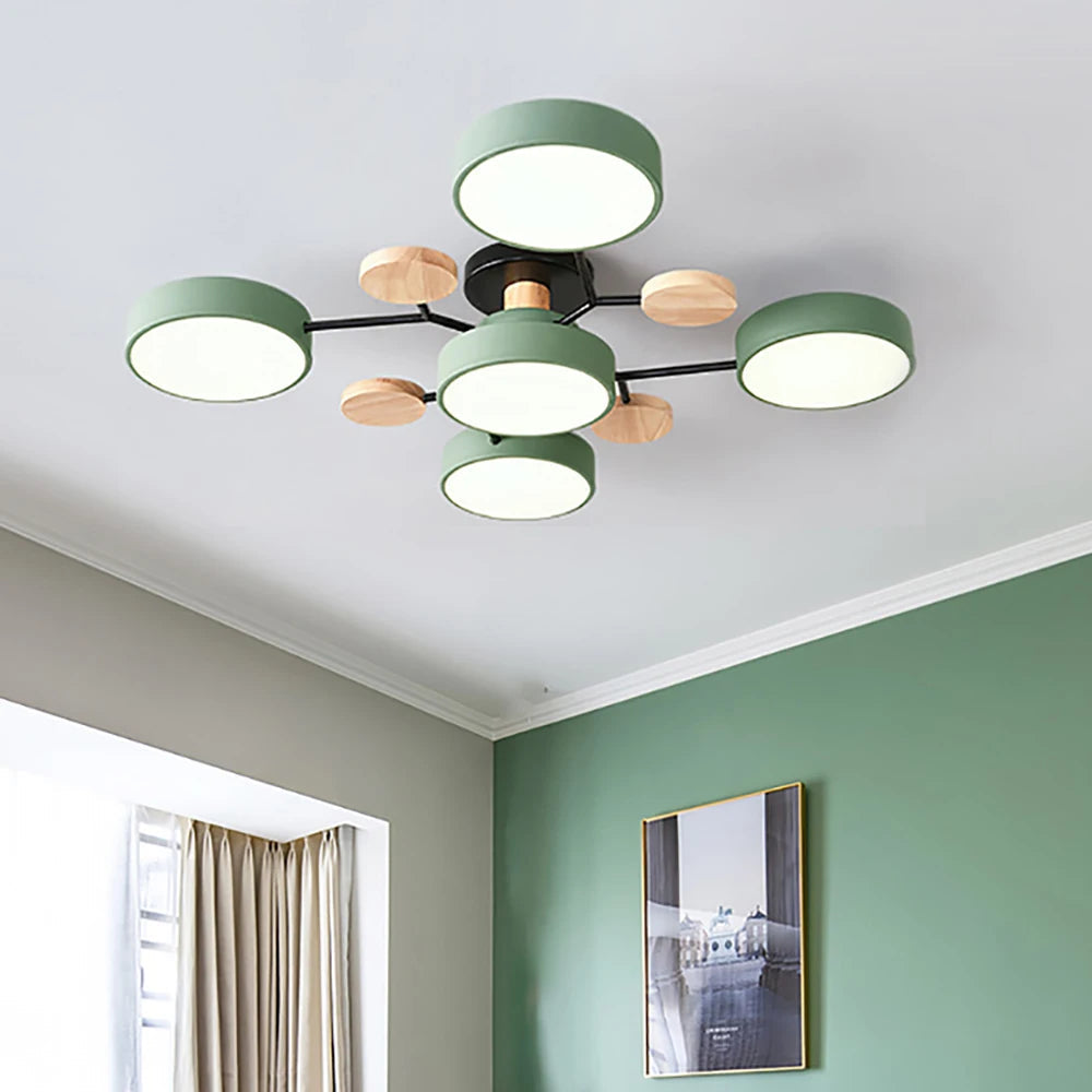 Green five-shade ceiling light with black arms and wood discs beside a green accent wall 4