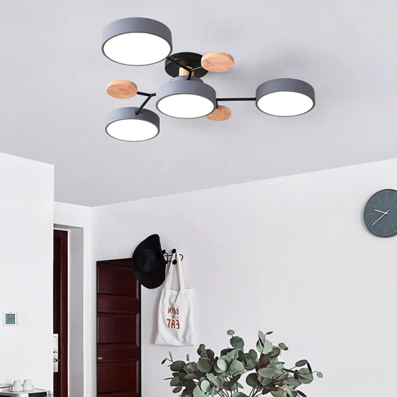 Gray four-shade ceiling light with black arms and wood discs in a white hallway 5