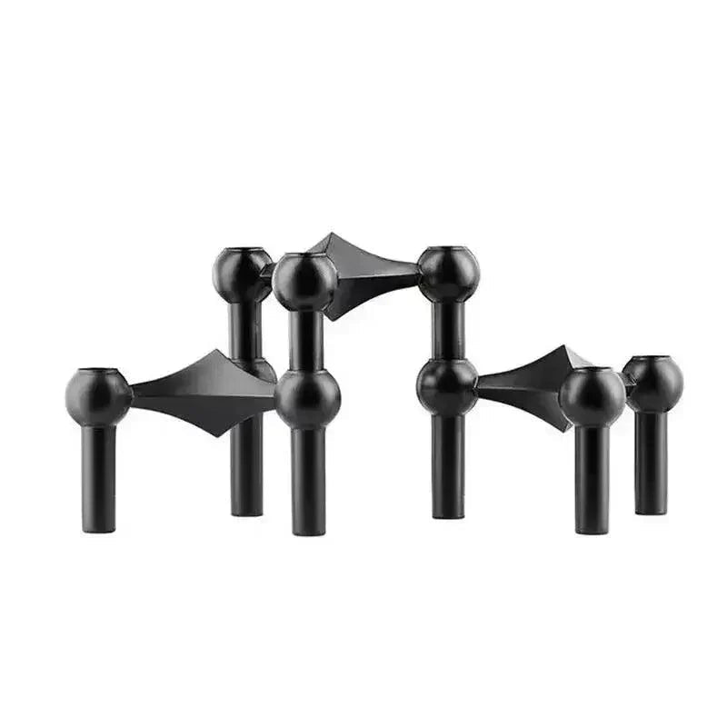 Three matte black modular candle holders with diamond-shaped connectors and ball sockets side by side on a white background.