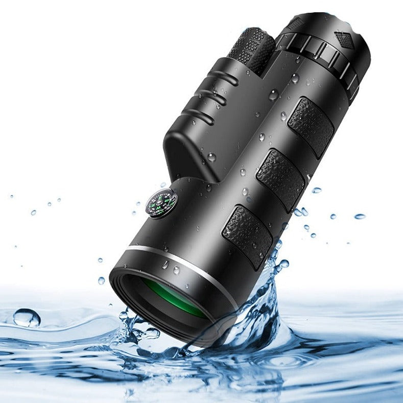 Black monocular with rubber grip panels and a small compass.