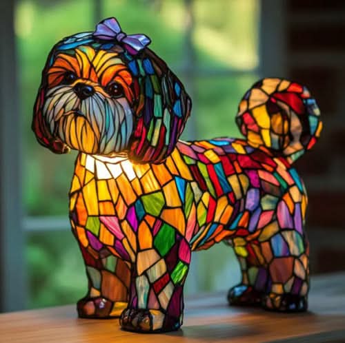 Small shaggy dog lamp with a purple bow, multicolored mosaic body and curled tail, glowing on a wooden table by a window. 23