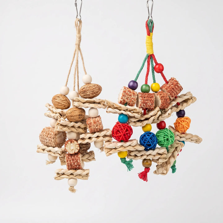Two hanging toys on a plain background: one with nuts, pale beads and jute cord, the other with bright beads, rattan balls and cotton tassels. 1