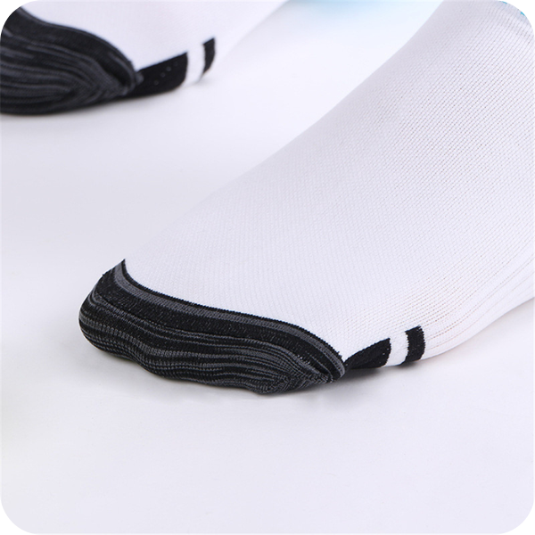 Detail of the sock toe with a dark gray reinforced toe cap and two black stripes on white fabric. 4