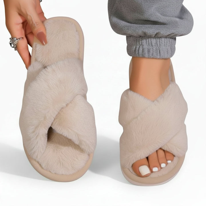 Cream plush crossband slippers, one on the foot with gray cuffed pants, one held up 7