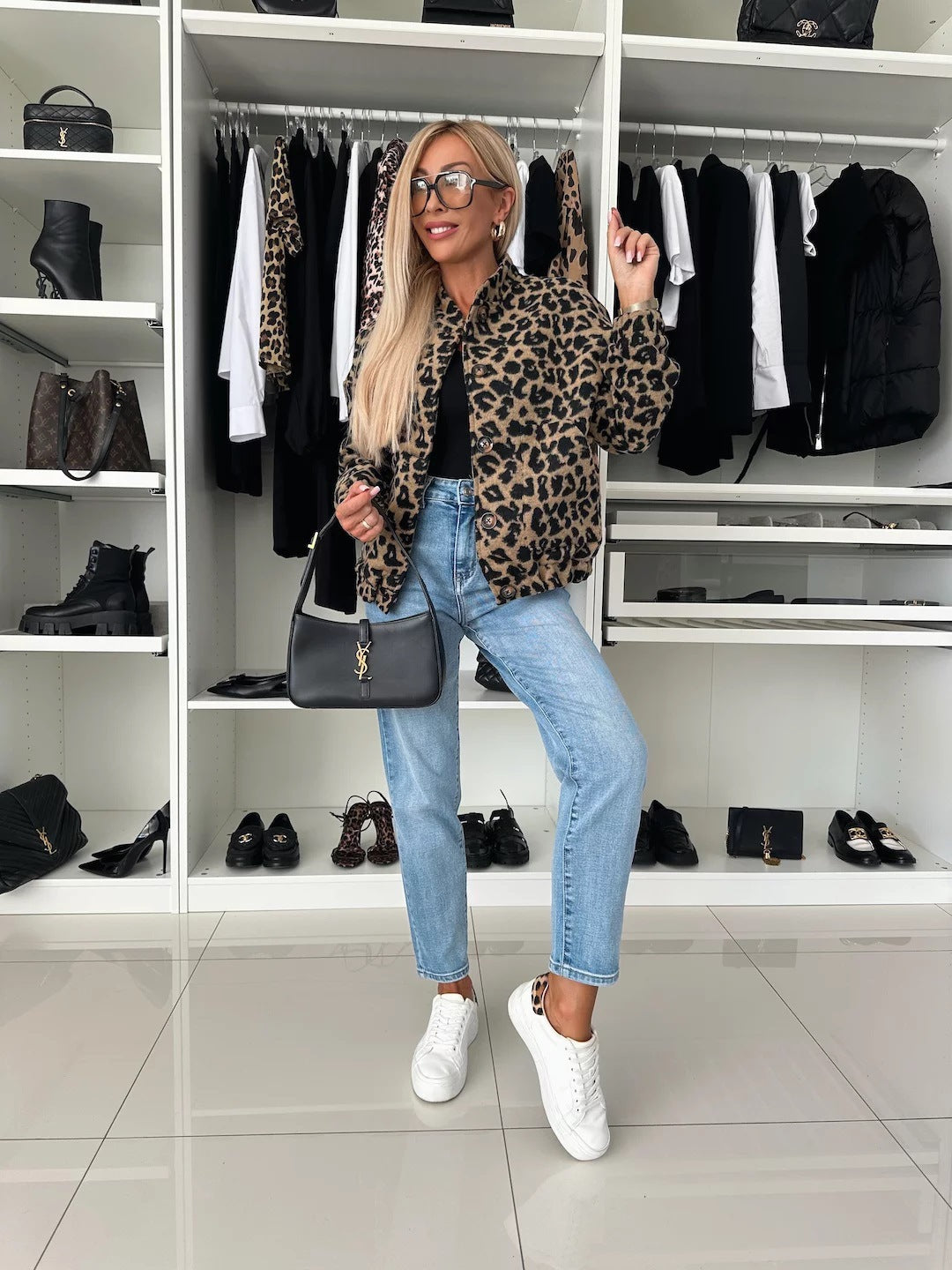 Full-length view of the leopard print jacket worn with a black top, light-wash jeans and white sneakers in a walk-in closet. 5