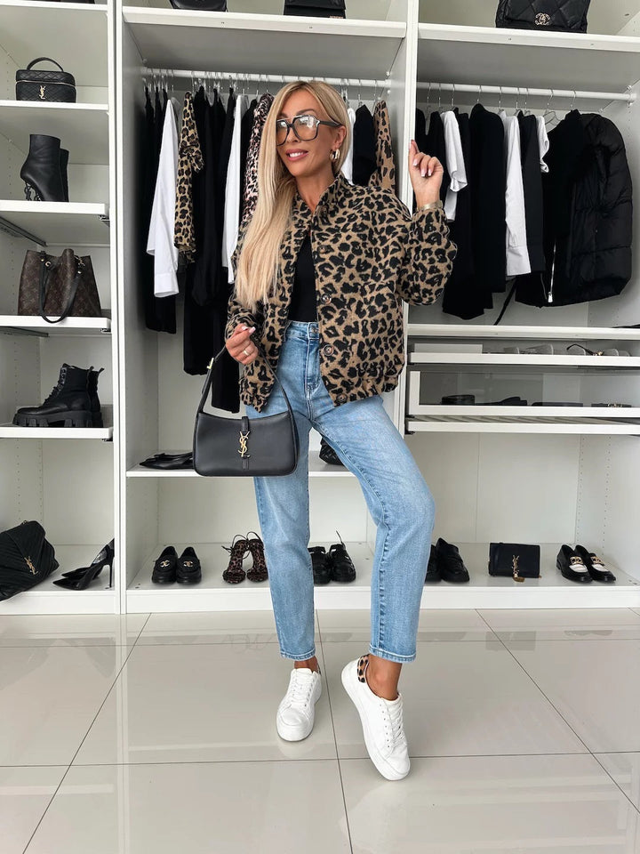 Full-length view of the leopard print jacket worn with a black top, light-wash jeans and white sneakers in a walk-in closet. 5