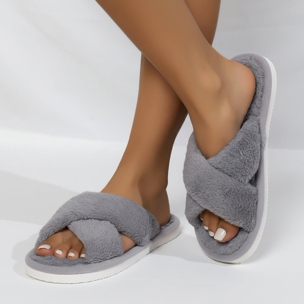 Gray plush crossband slippers worn by a model with crossed legs, white sole visible 5