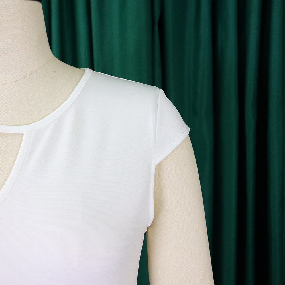 Weißes Damen-T-Shirt aus Baumwolle auf Schneiderpuppe vor grünem Vorhang.
