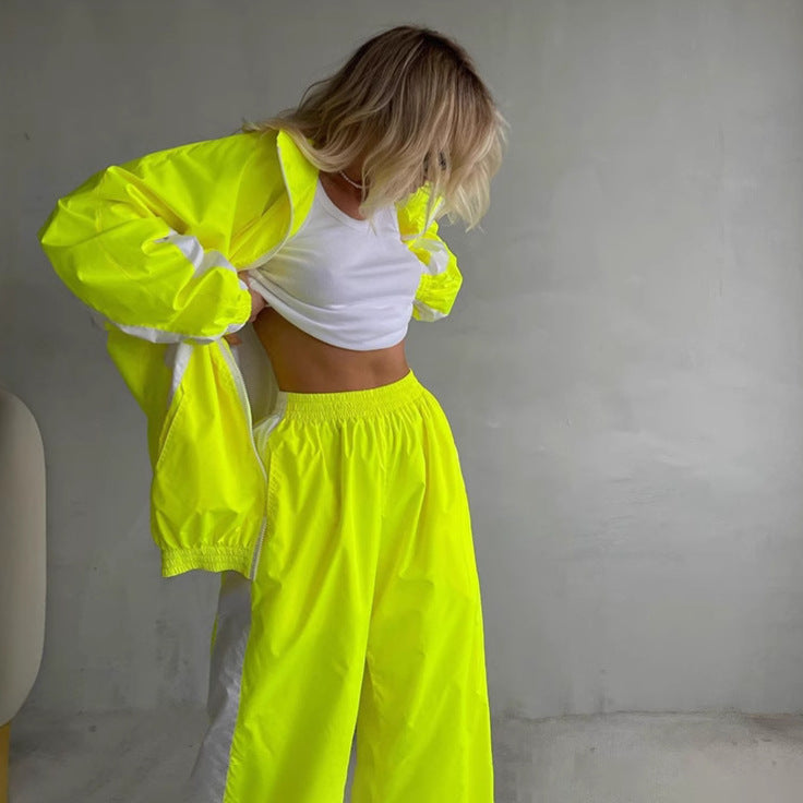 Women's windbreaker tracksuit set in neon yellow and white, another view with the matching jacket and pants.