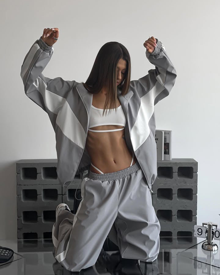 Women's windbreaker tracksuit set in gray and white, full-length view with the jacket open.