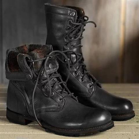 Pair of black lace-up boots, one with its cuff folded down to show a patterned fleece-style lining, on a wooden floor. 2