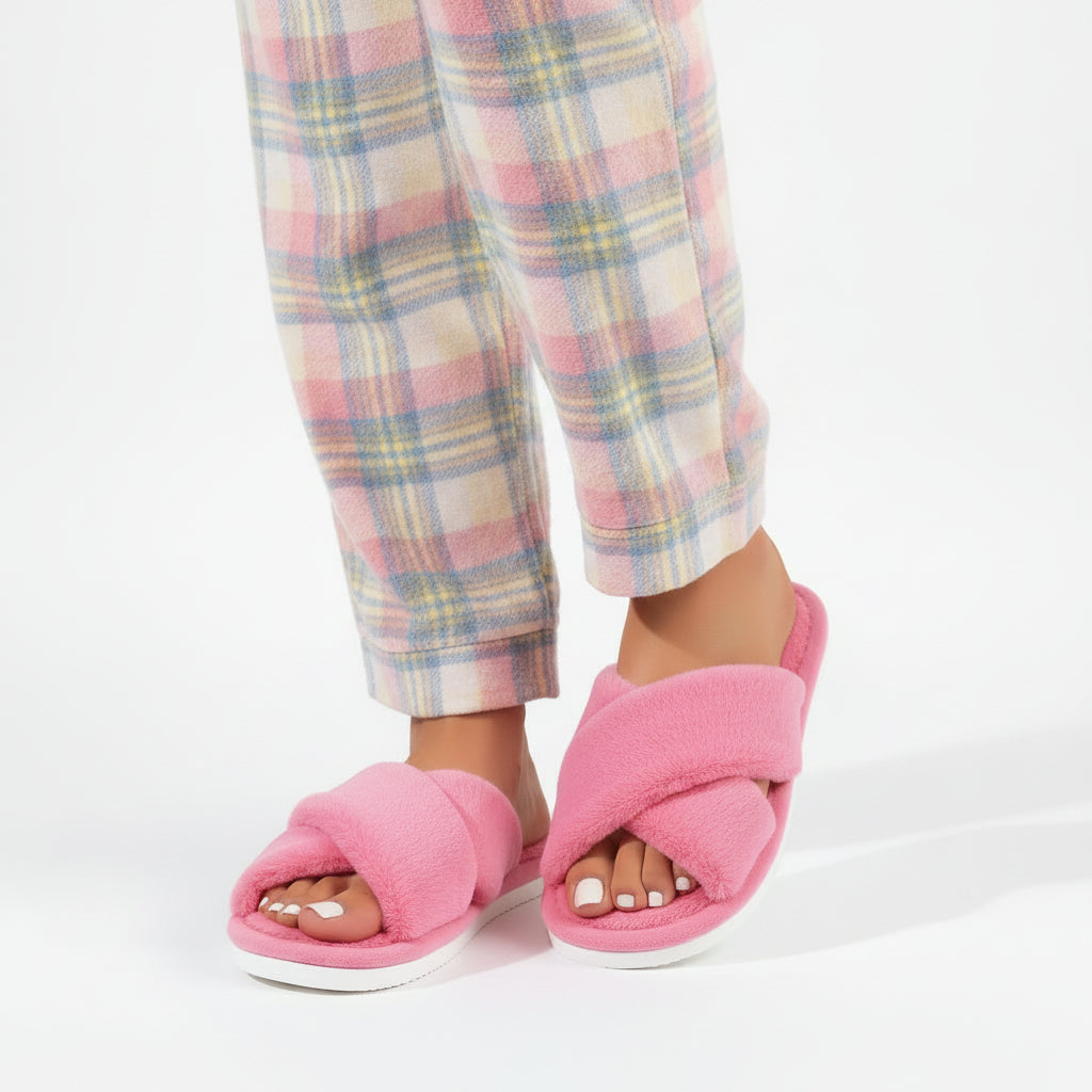 Woman wearing pink fluffy crossband slippers with pastel plaid pajama pants 2