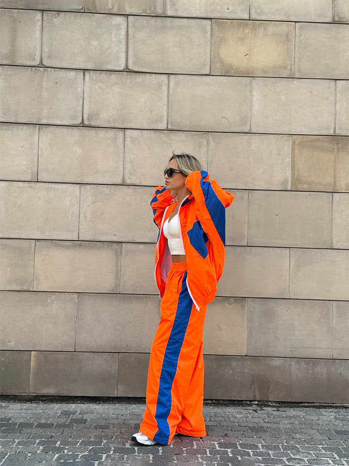 Women's windbreaker tracksuit set in bright orange and blue, another view of the side detail.
