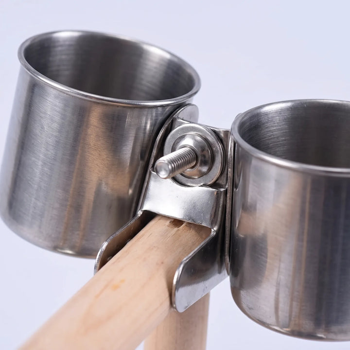 Close-up of the two stainless steel cups held by a metal clamp with a bolt on the wooden perch. 4