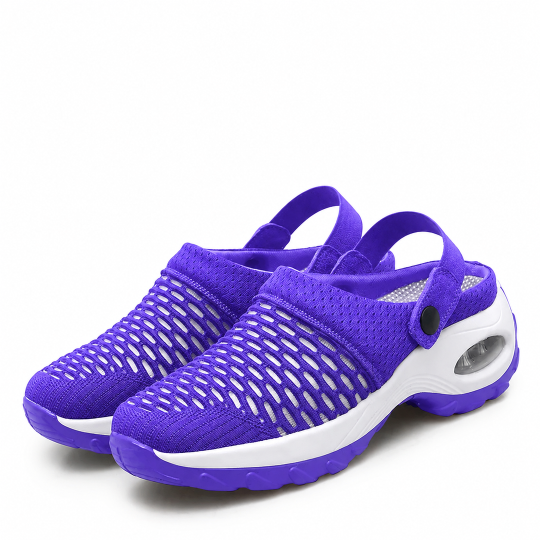 Pair of purple mesh clogs with open oval cutouts, a white air-cushion midsole and snap heel straps on a white background.